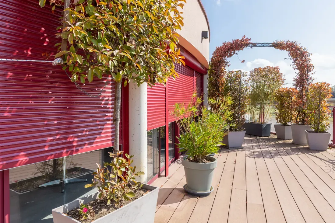 Volet roulant extérieur DECO solaire rouge sur une grande baie donnant sur un balcon