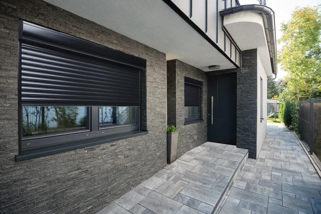 Maison en brique équipée de volets roulants extérieurs anthracite