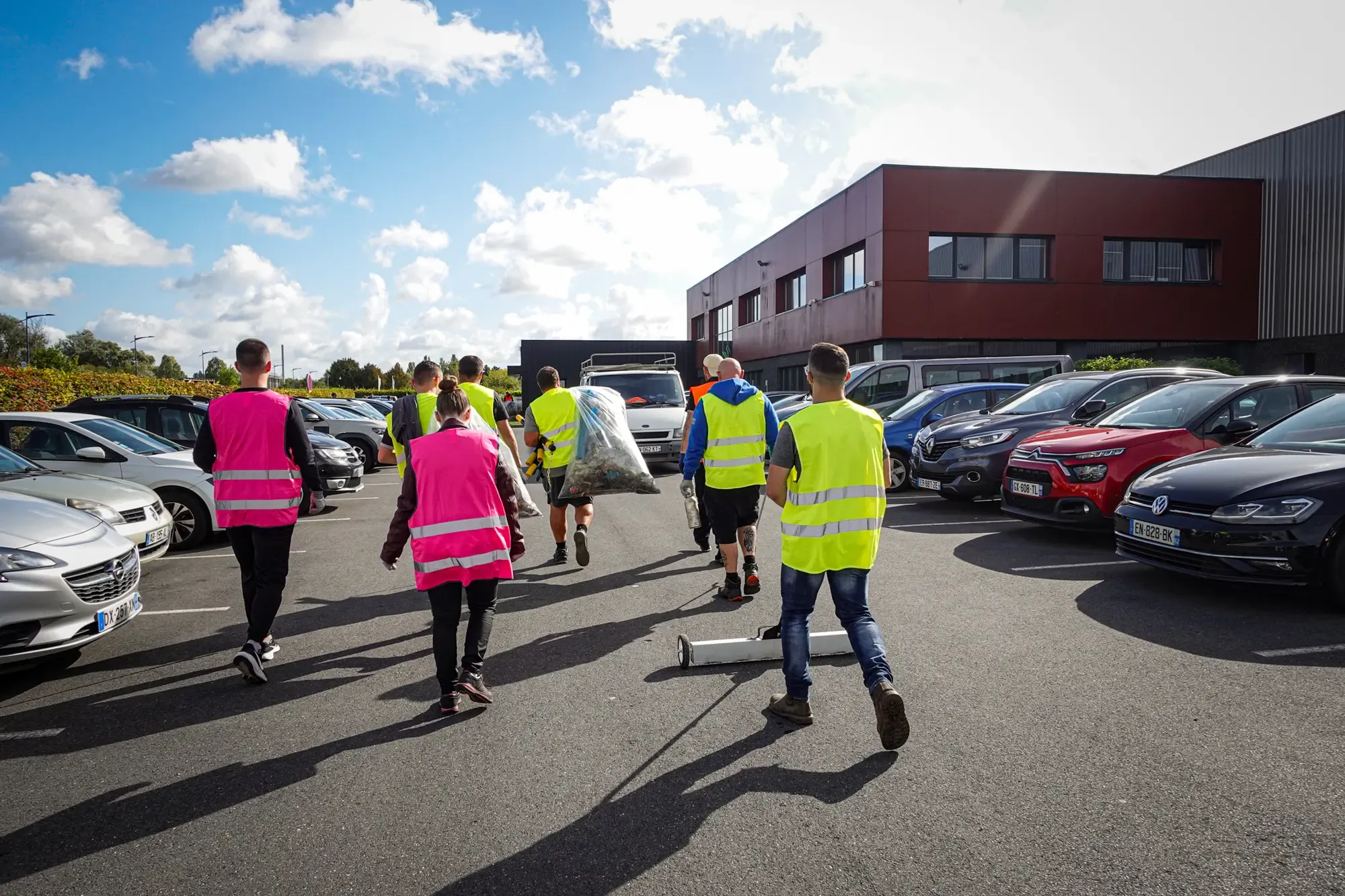 Collaborateurs PROFERM en gilets de sécurité traversant le parking du site de Douvrin, sacs de collecte à la main, lors du World CleanUp Day 2026